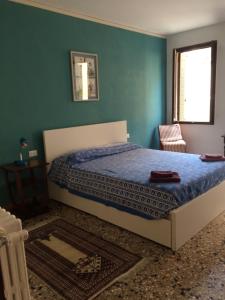 a bedroom with a bed with a blue wall at Cà Greta in Venice