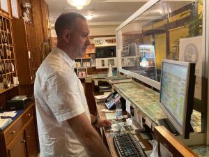 Un uomo in piedi davanti a un bancone con un computer di Hotel Ping Pong a Lido di Ostia