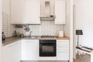 a kitchen with white cabinets and a stove top oven at SEA- ROOM-E in Ladispoli