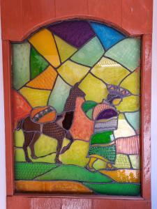 a stained glass window with a giraffe at Chelitos Backpacker in Cusco