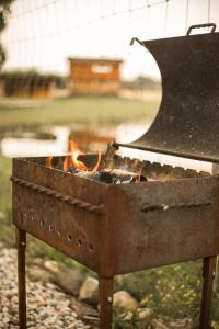 a grill with a fire inside of it at Arčiau gamtos Anykščiai in Kurkliai