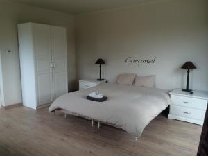 una camera con un letto e due cassettiere e due lampade di B&B Caramel a Turnhout