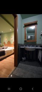 a bathroom with a sink and a bed and a mirror at B&B Villa Delle Rose in Roccaraso
