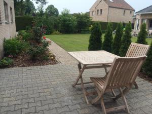 un tavolo in legno e 2 sedie su un patio di B&B Caramel a Turnhout