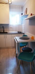 eine Küche mit einem Tisch, 2 Stühlen und einem Tisch in der Unterkunft Sandra Apartman in Sovata