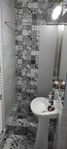 ein Badezimmer mit einem weißen Waschbecken und einer Dusche in der Unterkunft Sandra Apartman in Sovata