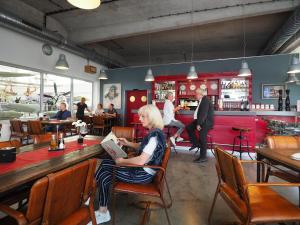eine Frau, die an einem Tisch in einem Restaurant sitzt in der Unterkunft Appartement "Karat" mit Penthouseflair - Oase am Haff in Garz