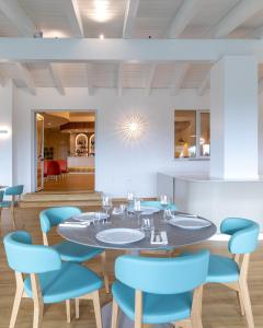 a dining room with a table and blue chairs at Lu' Hotel Porto Pino in SantʼAnna Arresi