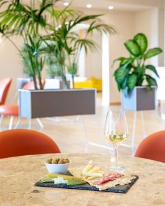 a table with a glass of wine and food on it at Lu' Hotel Porto Pino in SantʼAnna Arresi