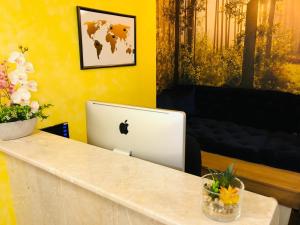 laptop jabłkowy siedzący na ladzie w pokoju w obiekcie Room Mate Hostel Amsterdam Zaandam w mieście Zaandam