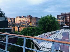 a building with a glass roof in a city at Space Hostel Amsterdam Zaandam in Zaandam