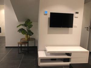 ein Wohnzimmer mit einem Flachbild-TV an der Wand in der Unterkunft bloc79/zero in Knokke-Heist