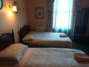 a hotel room with two beds and a window at Bellevue Guest House in Edinburgh