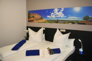 een slaapkamer met 2 bedden met witte kussens en een schilderij bij Mar Hotel in Marburg an der Lahn
