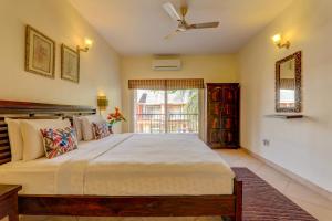 a bedroom with a large bed and a window at Heritage Nirvana Villa - 4BHK, Goa in Calangute