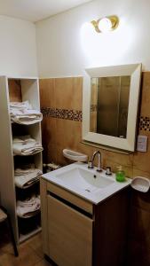 y baño con lavabo, espejo y aseo. en Rincon del Beagle en Ushuaia