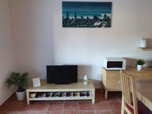 uma sala de estar com uma televisão e uma mesa em Apartment Belleview em Lagos