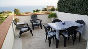 un patio con tavolo, sedie e vista sull'oceano di Deep Sea Residence a Agrigento