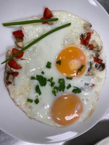 ein Teller Eier auf einem Teller mit Speck und Gemüse in der Unterkunft Alte Schmiede zu Trarbach in Traben-Trarbach