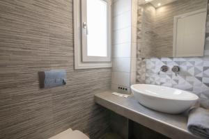 łazienka z białą umywalką i lustrem w obiekcie Petra Aqua Villa w mieście Perissa +37 zdjęć