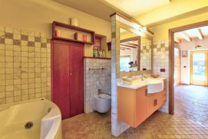 a bathroom with a tub and a toilet and a sink at chalet con piscina e vista panoramica in Colico