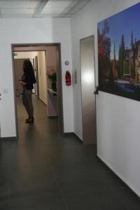 een vrouw die door een gang loopt in een gebouw bij Mar Hotel in Marburg an der Lahn