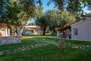 a rock in the grass next to a house at Il Mirto Residence in Marina di Camerota