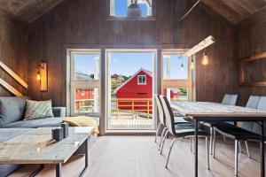 a living room with a table and a red barn at Kronborg marina in Averoy