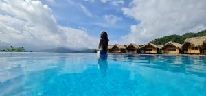 una mujer parada en el agua en una piscina del resort en Hoang Su Phi Lodge, en Ha Giang