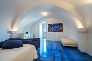 um quarto com duas camas e um piso azul em Hotel Grotta Palazzese em Polignano a Mare