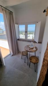 pokój ze stołem i dwoma krzesłami oraz oknem w obiekcie Hospedería Boutique by La Judería De Vejer- ADULTS ONLY w mieście Vejer de la Frontera