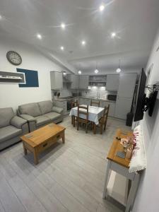 ein Wohnzimmer mit einem Sofa und einem Tisch in der Unterkunft Ty Bach in Bagilt