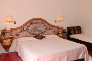 a bedroom with two beds with a large headboard at Torre Bennistra in Scopello