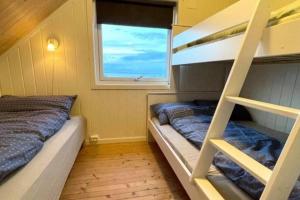 2 Etagenbetten in einem Zimmer mit Fenster in der Unterkunft Lofoten_Beach_Eggum in Eggum