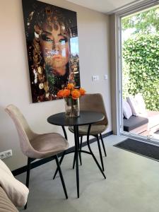 una mesa y sillas en una habitación con una pintura en Petite Maison Bennebroek en Bennebroek