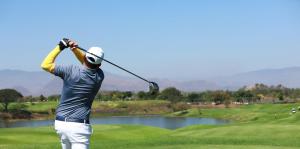 a man swinging a golf club on a golf course at Petite Maison Bennebroek in Bennebroek