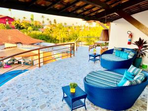 a patio with blue chairs and tables on a resort at Hotel e Pousada Cumbuco Guesthouse in Cumbuco