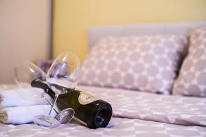 un paio di bicchieri da vino su un tavolo accanto al letto di Studio BM a Ruma
