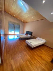 two beds in a large room with wooden floors at Villa Las Palmeras in Tarragona