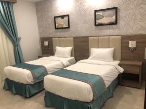 Postel nebo postele na pokoji v ubytování Al-Haramain Family Apartments