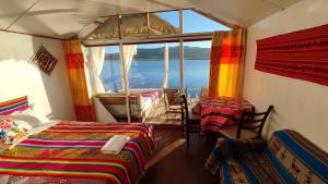 a room with three beds and a large window at Titicaca Aruntawi Lodge Peru in Puno