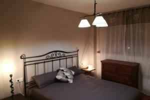 a bedroom with a bed and a dresser and two lights at Cèntric allotjament A RIALP in Rialp