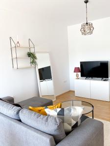a living room with a couch and a glass table at Maslina Apartments in Široki Brijeg
