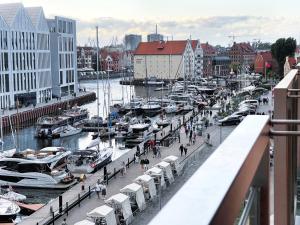 een jachthaven met boten en mensen die op een dok lopen bij Apartament Waterlane w oknami na rzekę - Marina View in Gdańsk