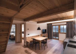 a dining room and living room with a table and chairs at Unterweckerlerhof in Valle Di Casies