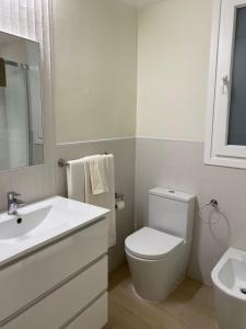 Un baño blanco con inodoro y lavabo. en Manila Playa, en Almuñécar 61 fotos más