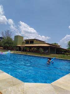 una persona sosteniendo una paleta en una piscina en Casa Verde en Pirenópolis