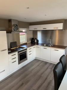 a kitchen with white cabinets and a stove top oven at Luxe Chalet 146 in Putten