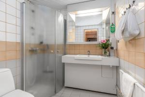 een badkamer met een douche en een wastafel bij Hotel Kurikka in Kurikka