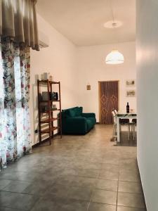 a living room with a green couch and a table at Nonna Lucia in Molfetta +10 photos